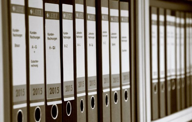 Raccoglitori fiscali per fatture cartacee in ufficio, simbolo della gestione amministrativa tradizionale.