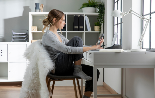 Donna freelance lavora da casa con laptop e smartphone